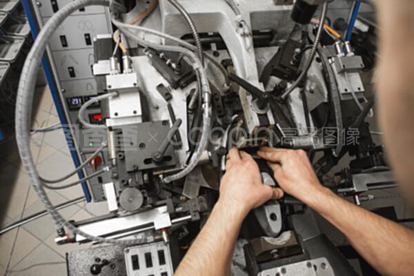 男人用特殊的機械工具制鞋。鞋廠的輸送機,有鞋底和鞋底。